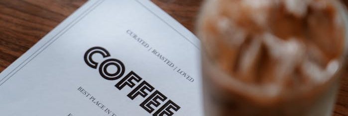 A Coffee Menu Placed on Brown Surface
